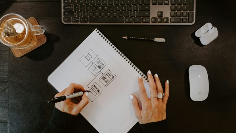 User drawing flow diagram on desk